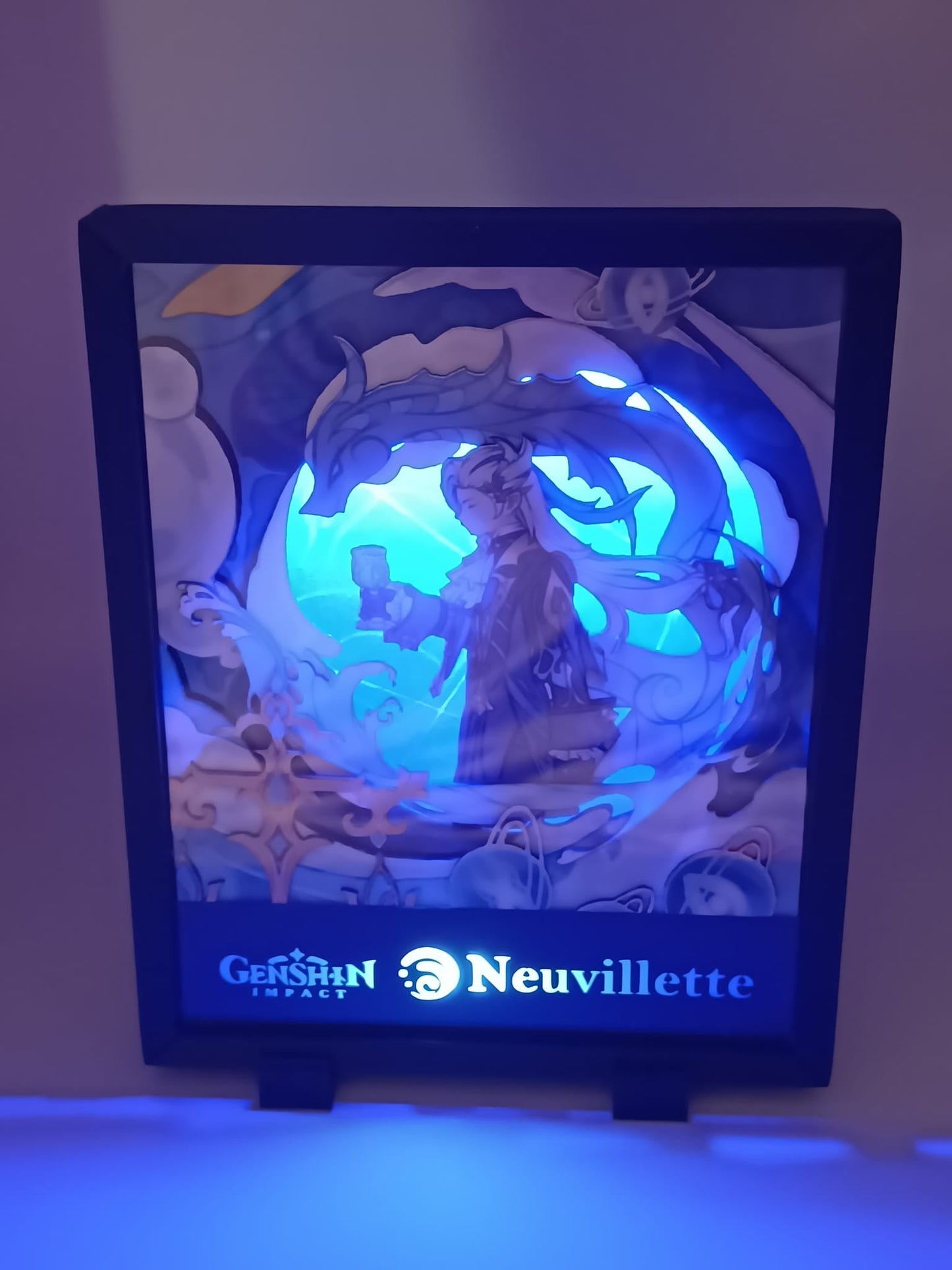 Lightbox artigianale Neuvillette accesa, illuminazione blu, personaggio di Genshin Impact in cornice numerata.
