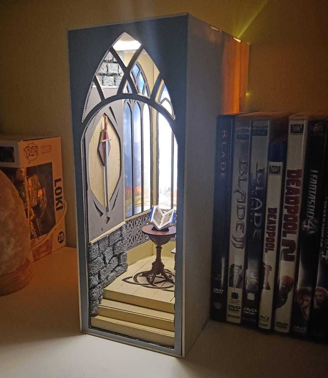 Book Nook fantasy artigianale, dettagli incantevoli, libreria trasformata in portale magico.