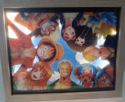 Un'immagine Lightbox incorniciata, "One Piece - Crew" di L'Atelier di Zelda, mostra vivaci personaggi pirati di One Piece che formano un cerchio sotto un cielo luminoso, ognuno con espressioni uniche che riflettono il loro spirito avventuroso.