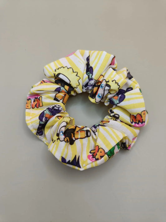 Scrunchie Naruto con personaggi chibi e sfondo giallo