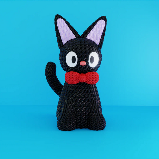 Statua artigianale di Jiji in PLA stile crochet con fiocco rosso, su licenza NaraaPrints, su sfondo azzurro